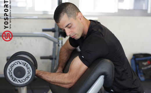 מאמן כושר מכווץ יד עם משקולת מתוך פוסט כיצד לבנות שרירים - cluster set שיטת האימון שלא הכרתם